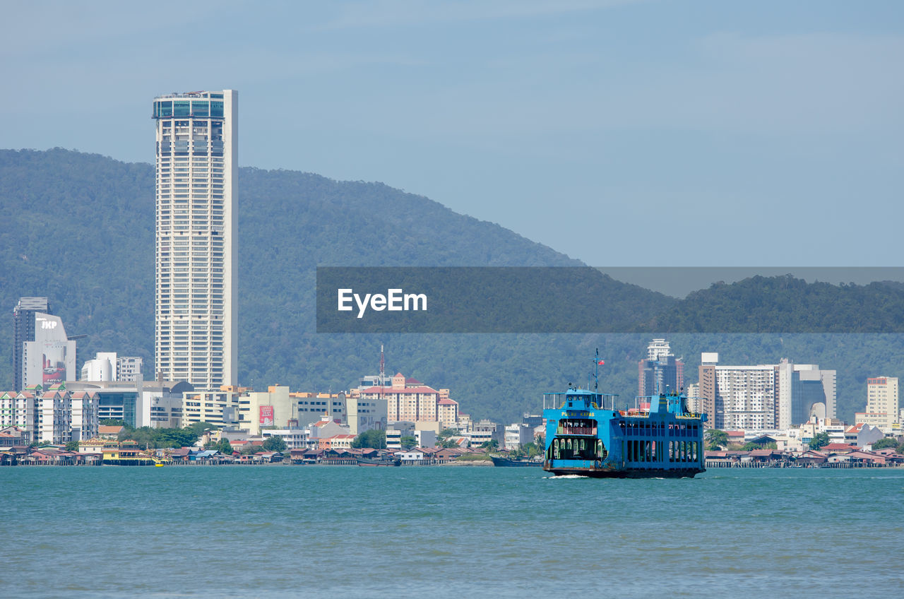 BOATS IN SEA AGAINST BUILDINGS