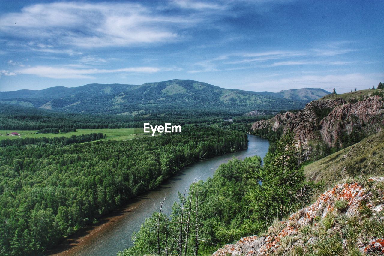 Scenic view of river amidst green landscape against sky