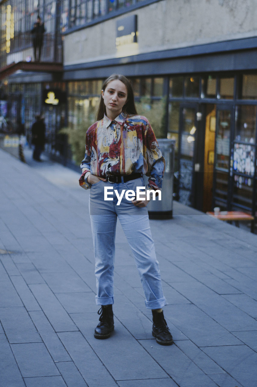 Portrait of young woman standing in city