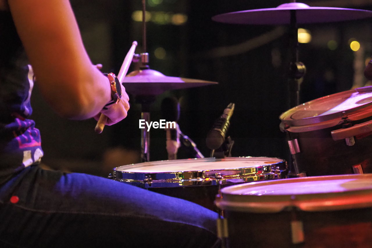 Midsection of man playing drum