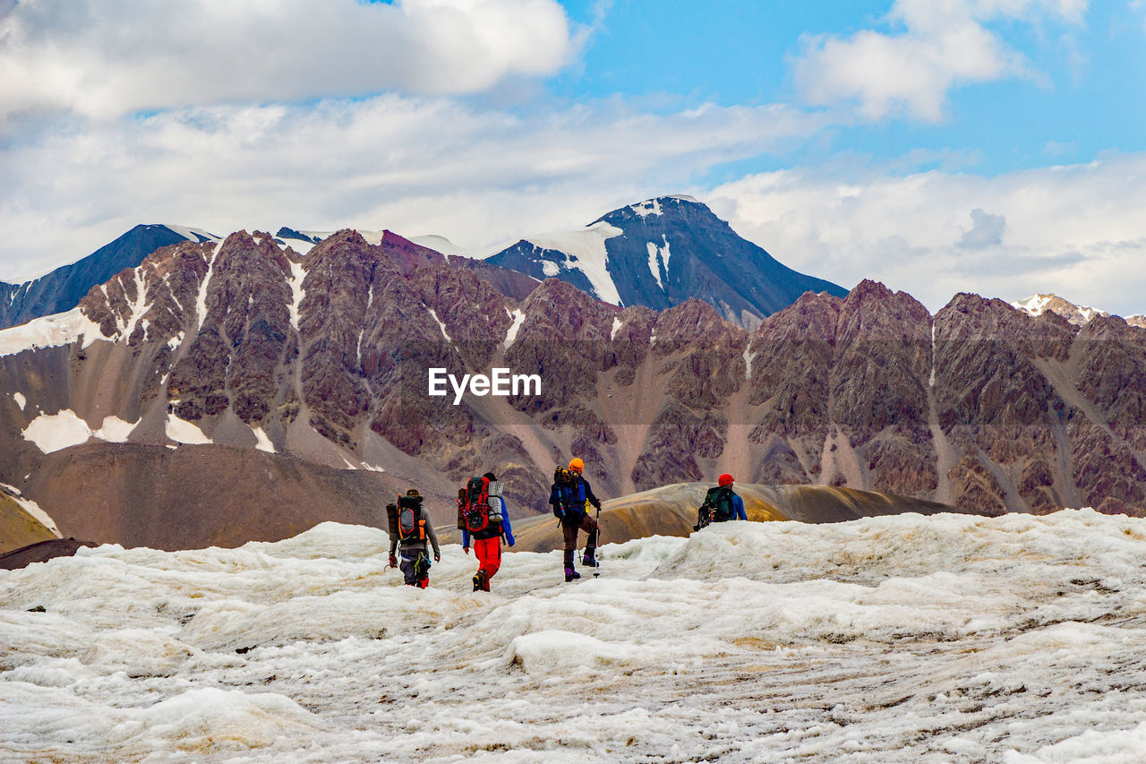 MEN WITH MOUNTAINS IN BACKGROUND