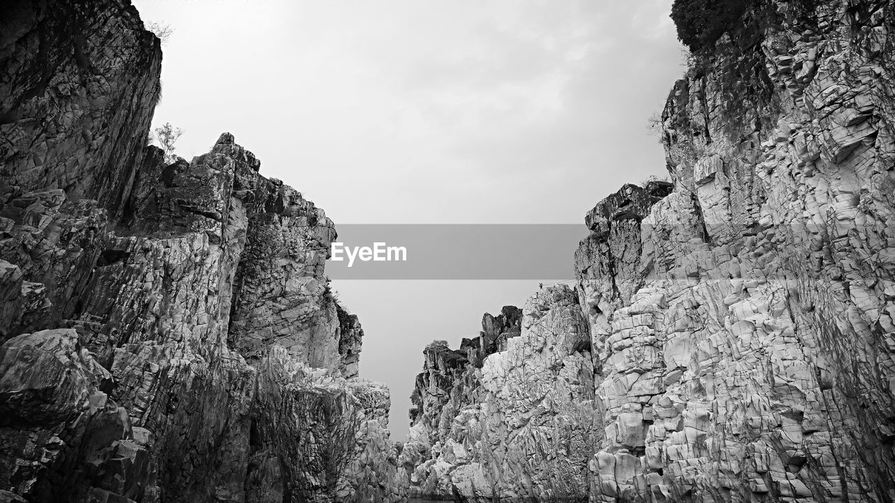 Low angle view of rocky mountains against sky