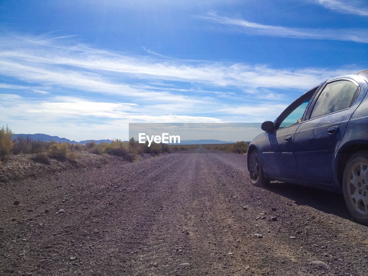 Cars on road against cloudy sky