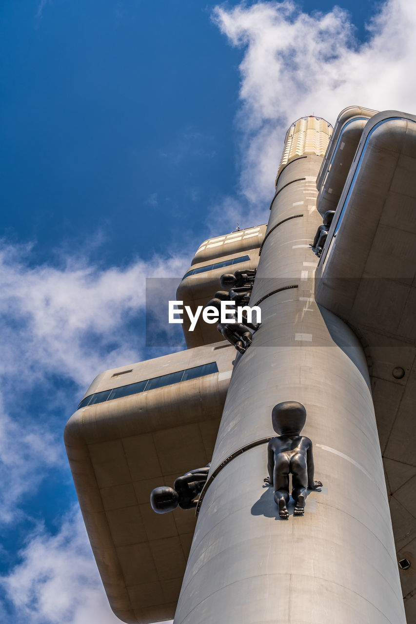 LOW ANGLE VIEW OF AIRPLANE ON FACTORY AGAINST SKY