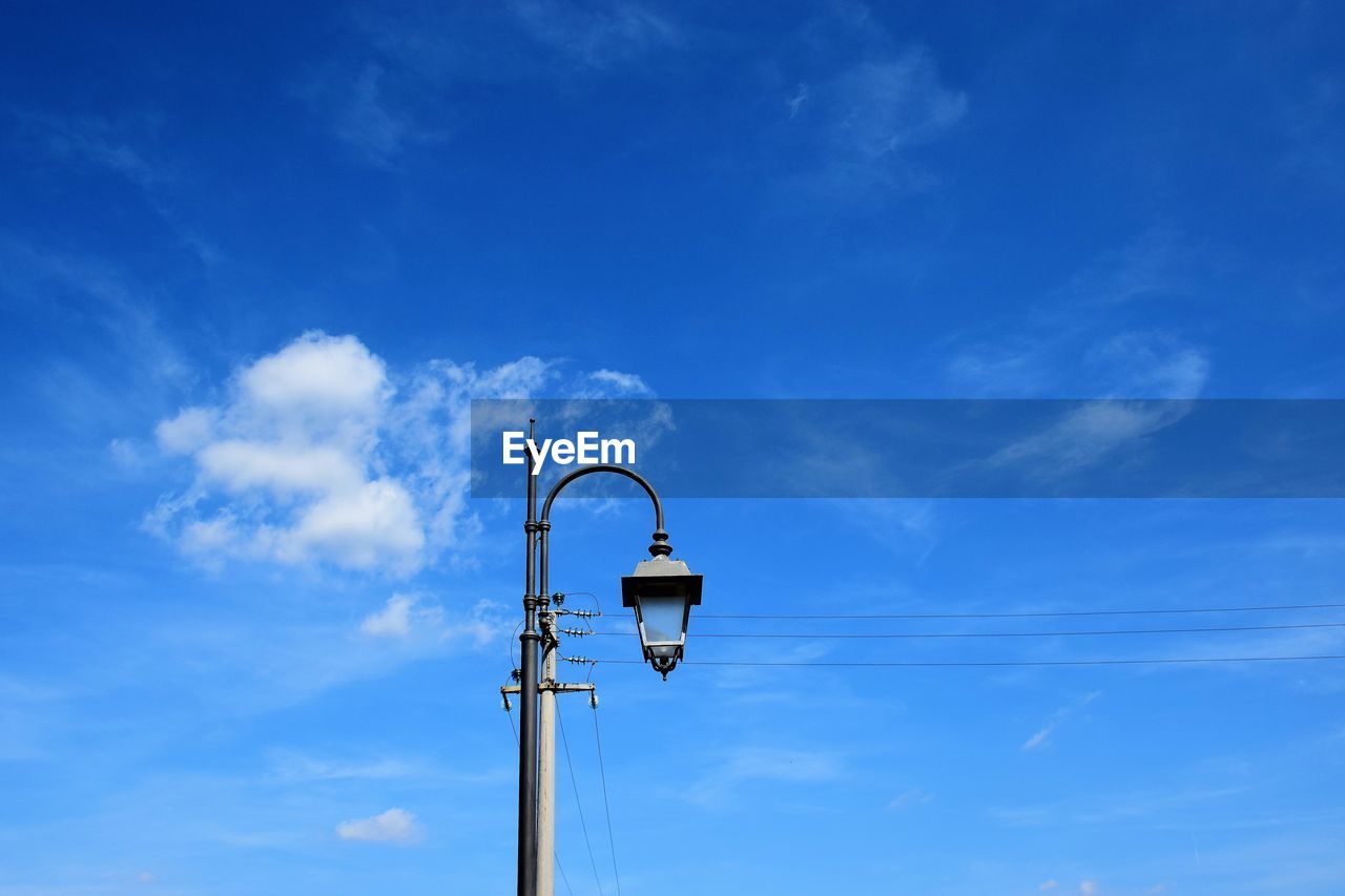 Low angle view of street light against blue sky