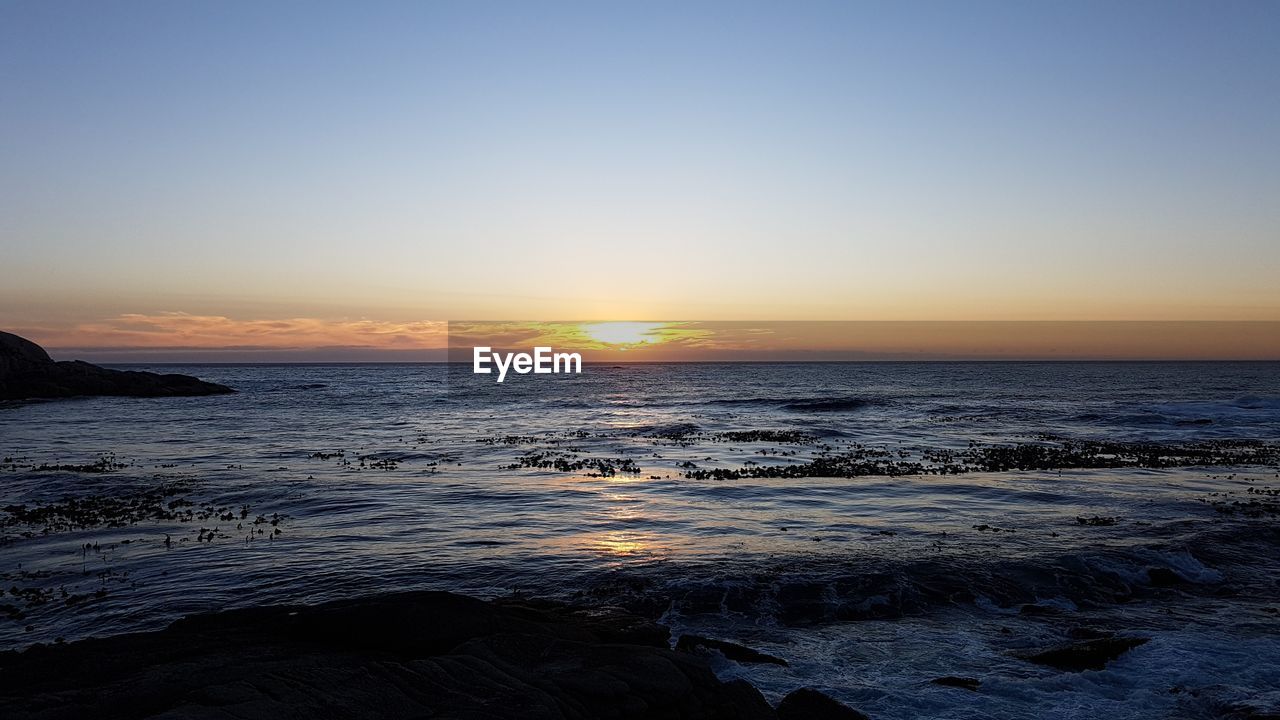 SCENIC VIEW OF BEACH AGAINST SKY DURING SUNSET