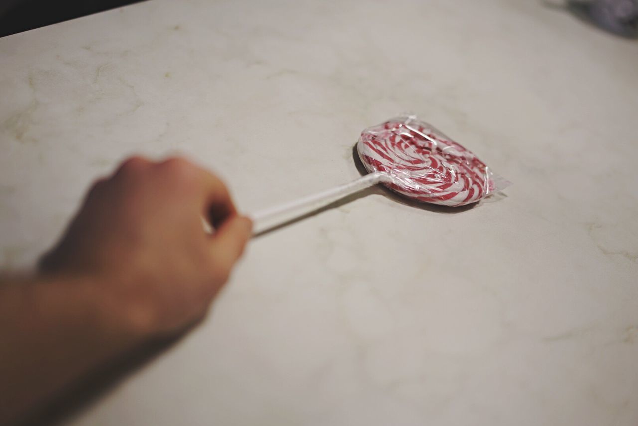 Close-up of hand picking up lollipop