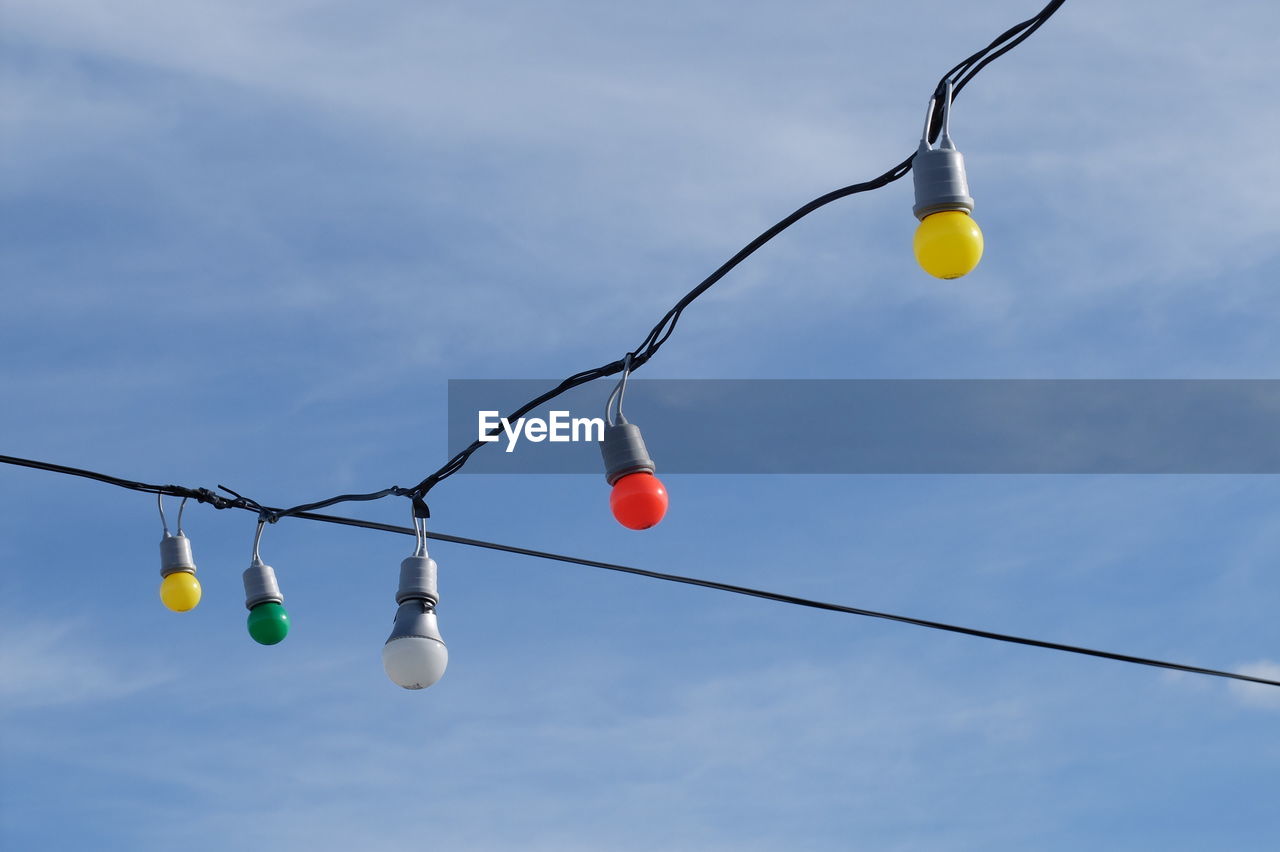 Low angle view of light bulbs against sky