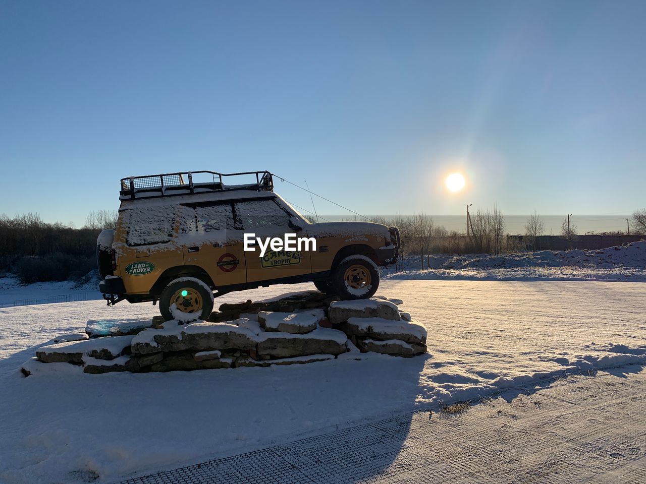 CAR ON SNOW COVERED LAND AGAINST CLEAR SKY