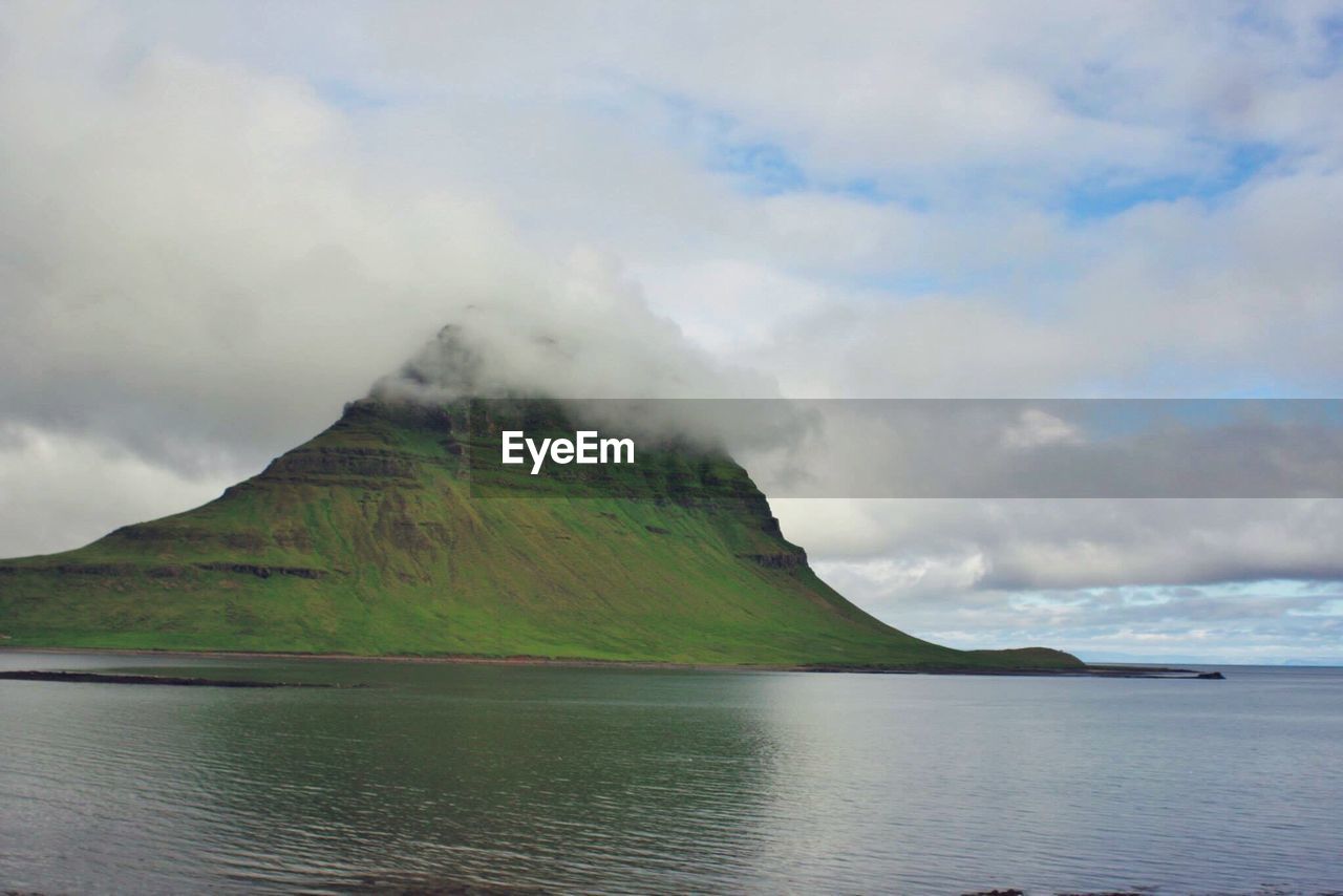 Scenic view of calm lake against cloudy sky