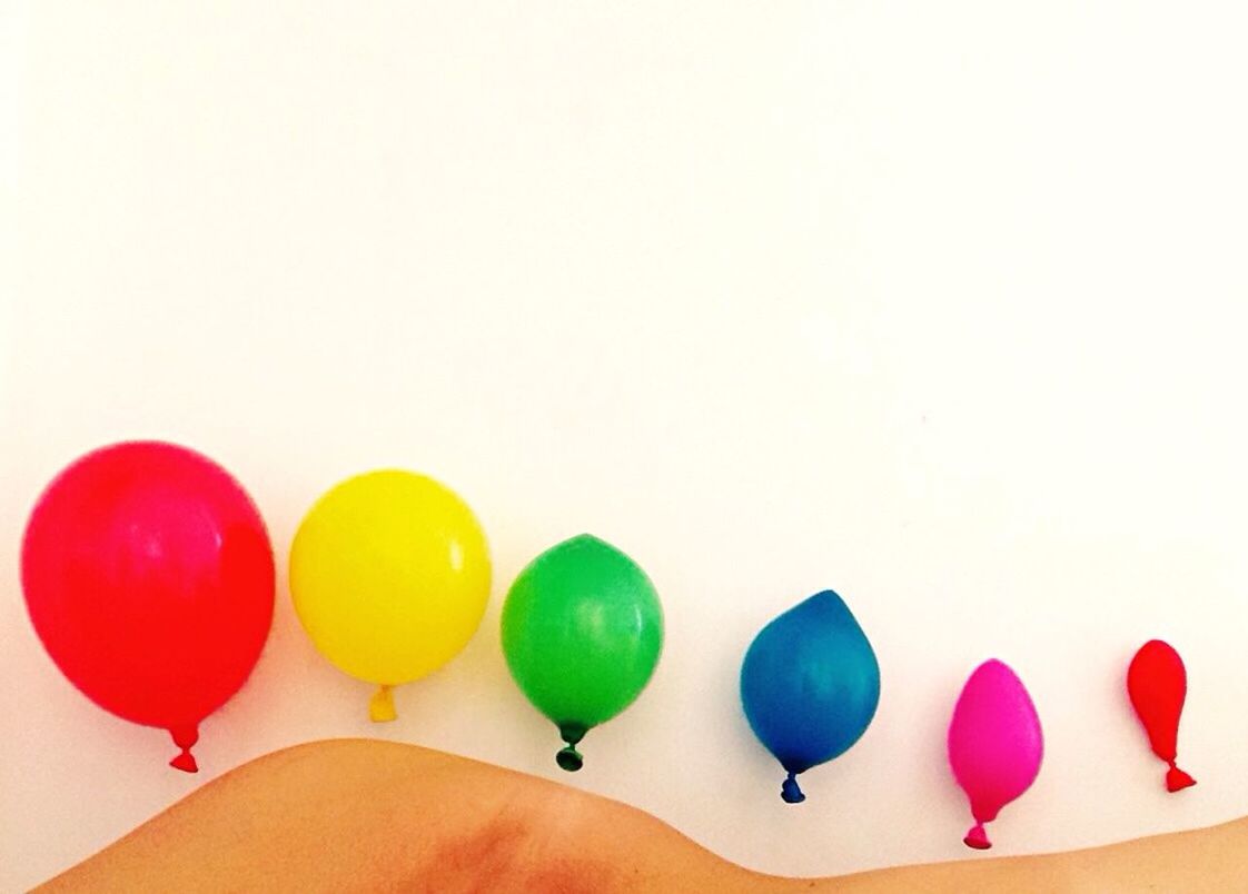 MULTI COLORED BALLOONS OVER WHITE BACKGROUND