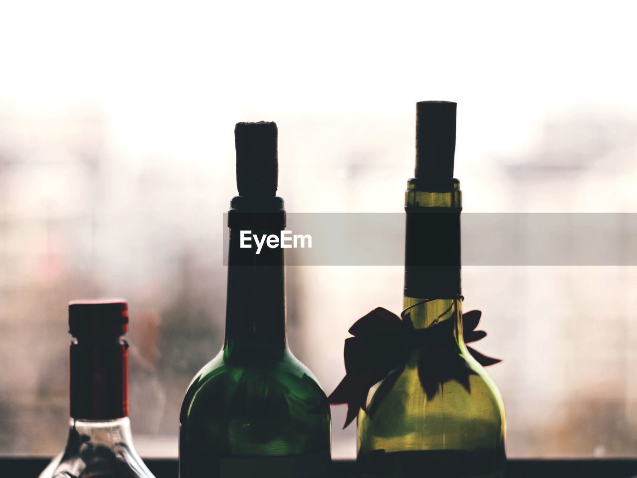 Close-up of wine bottles against window