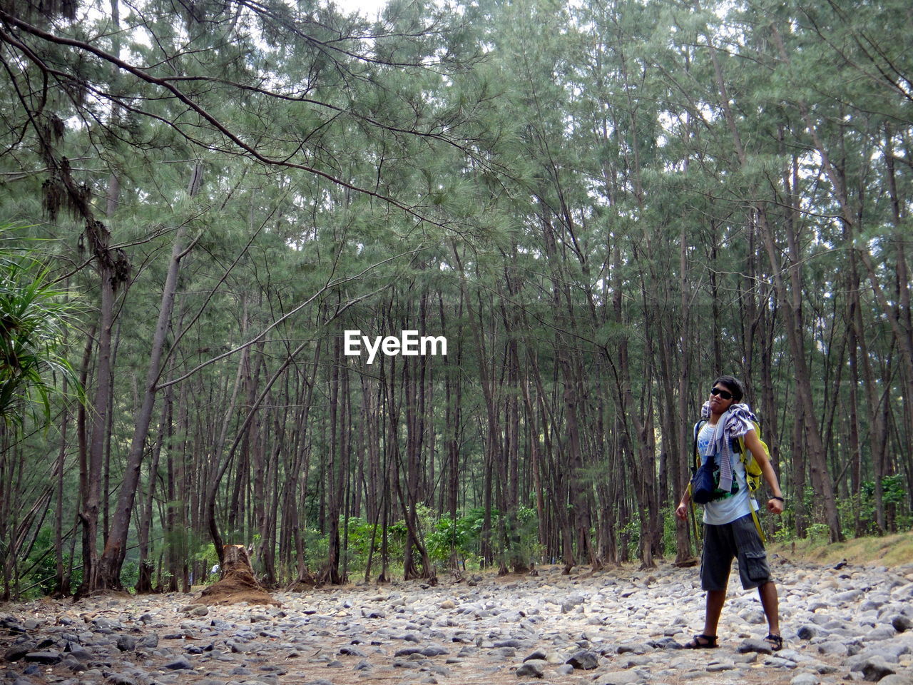 FULL LENGTH OF WOMAN WALKING ON ROAD IN FOREST