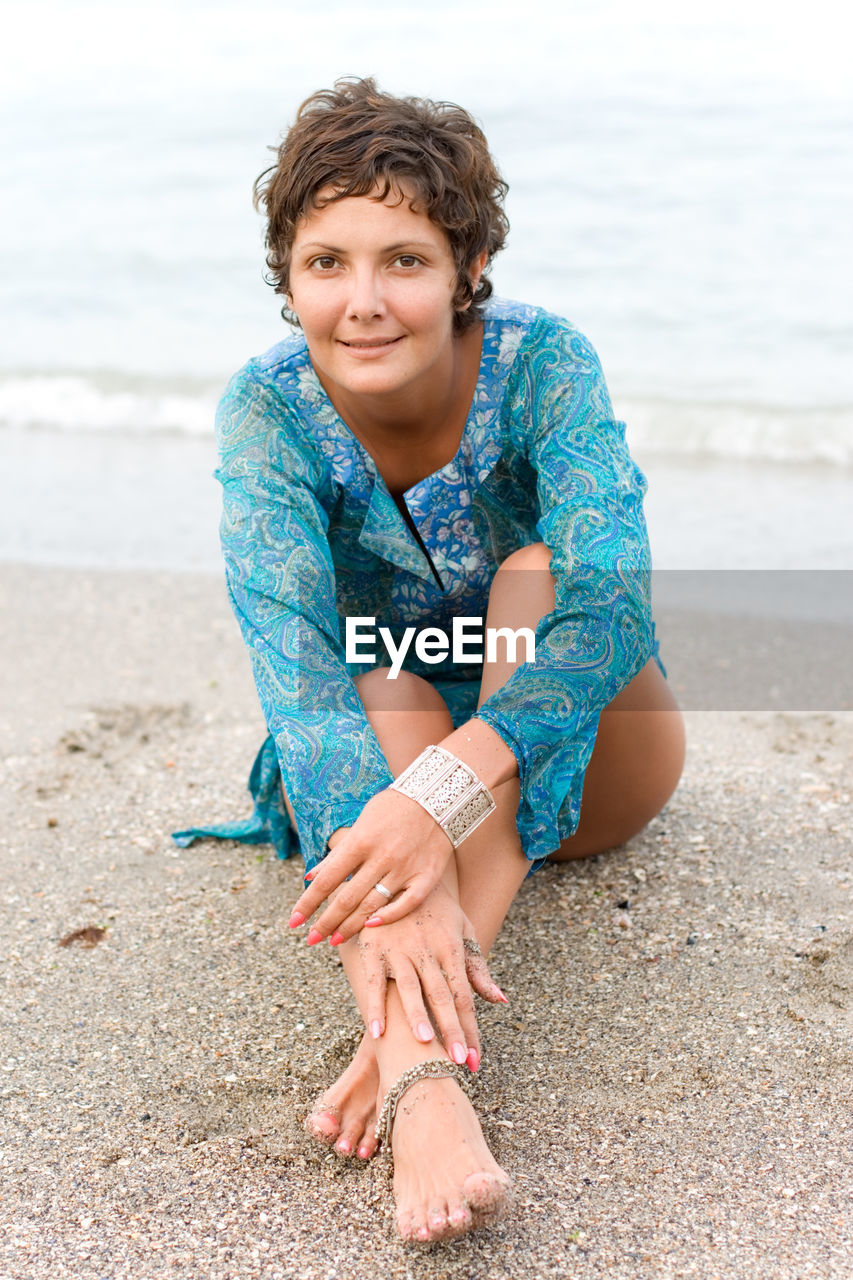 Portrait of smiling woman sitting on beach