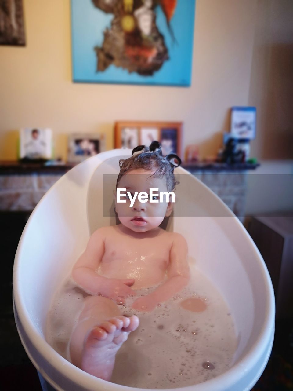 Portrait of shirtless boy in bathtub at home