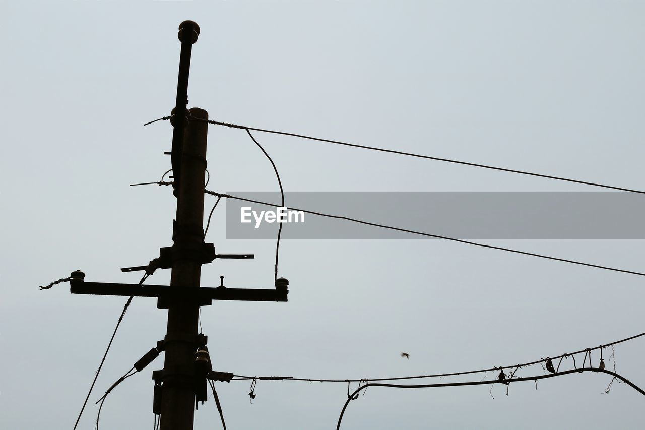 Low angle view of electric pole against clear sky