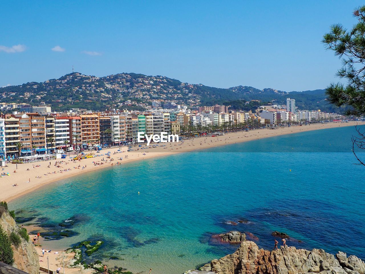 Scenic view of sea by buildings against blue sky