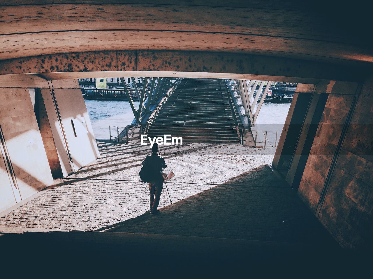 Rear view of man walking in tunnel