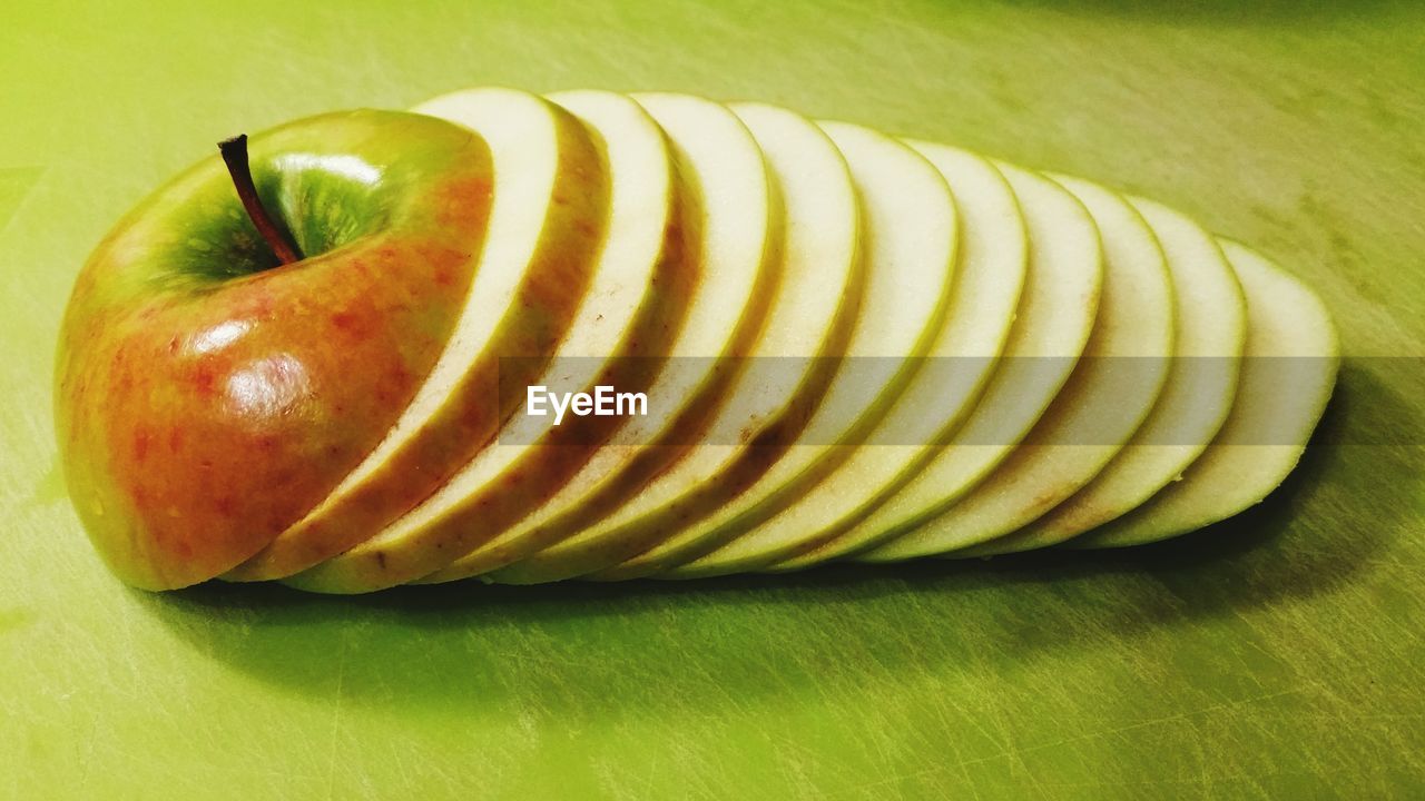 Close-up of sliced apples on green table