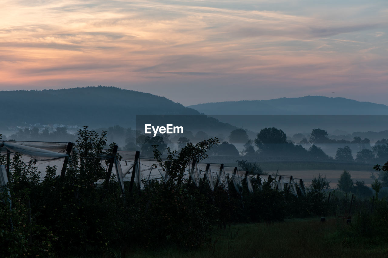 SCENIC VIEW OF MOUNTAINS AGAINST SKY AT SUNSET