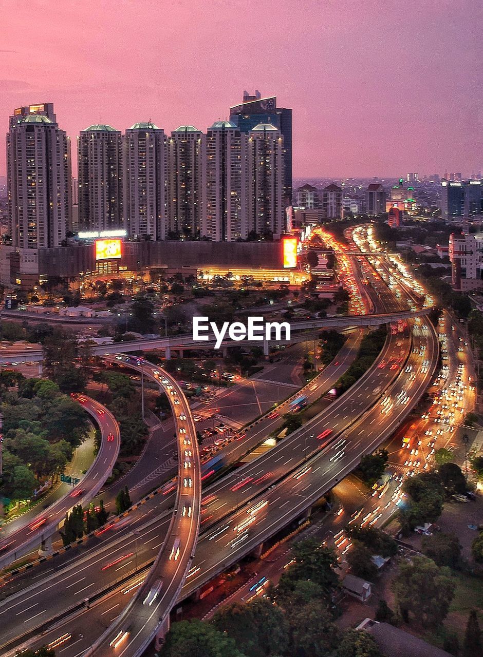 High angle view of illuminated street amidst buildings at night