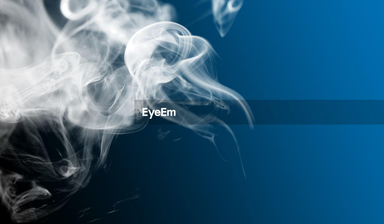 Close-up of smoke against blue background