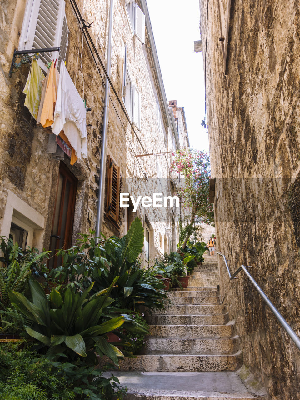 LOW ANGLE VIEW OF ALLEY AMIDST BUILDINGS