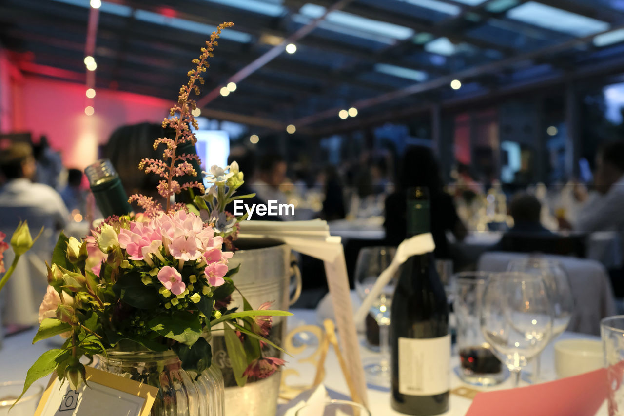 Evening event with flowers and wine bottles on the tables