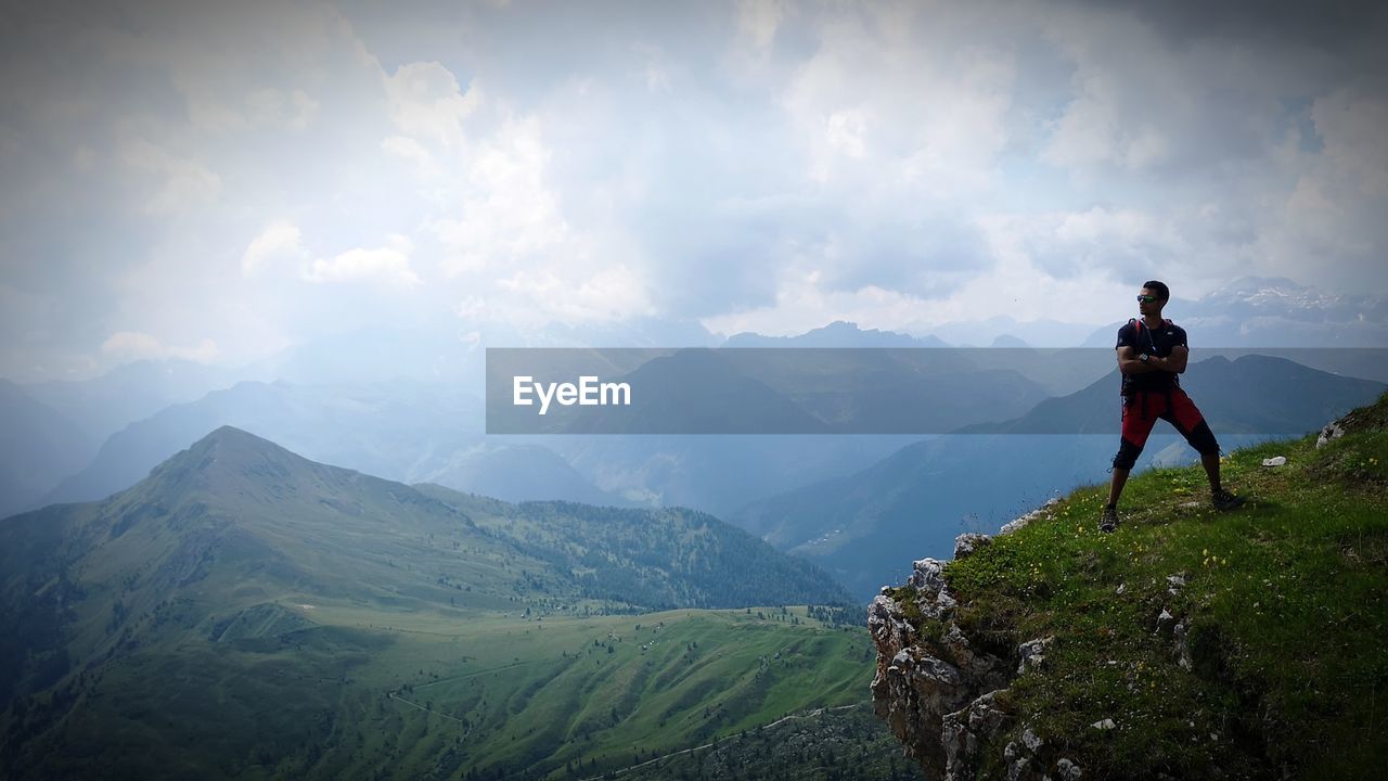 FULL LENGTH OF MAN STANDING ON MOUNTAINS AGAINST SKY