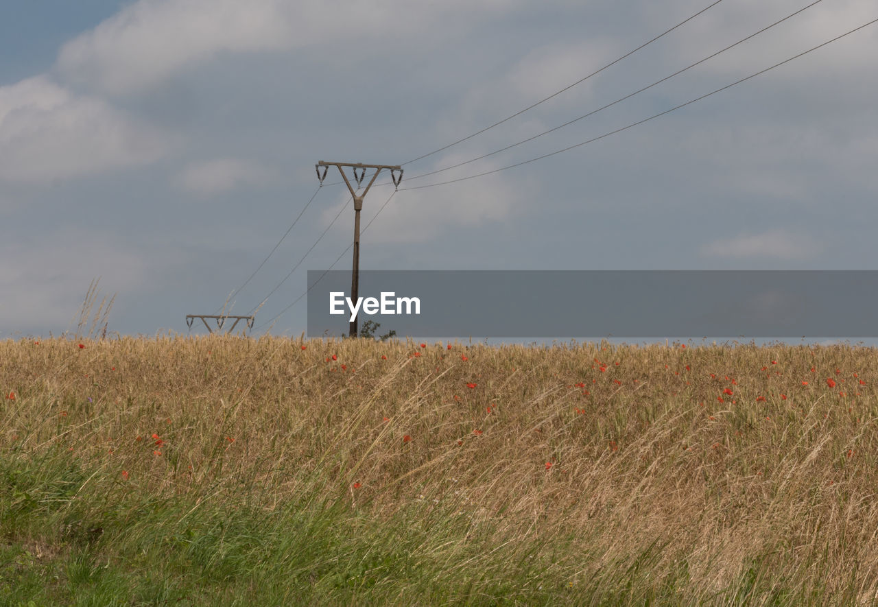 VIEW OF ELECTRICITY PYLON ON FIELD AGAINST SKY