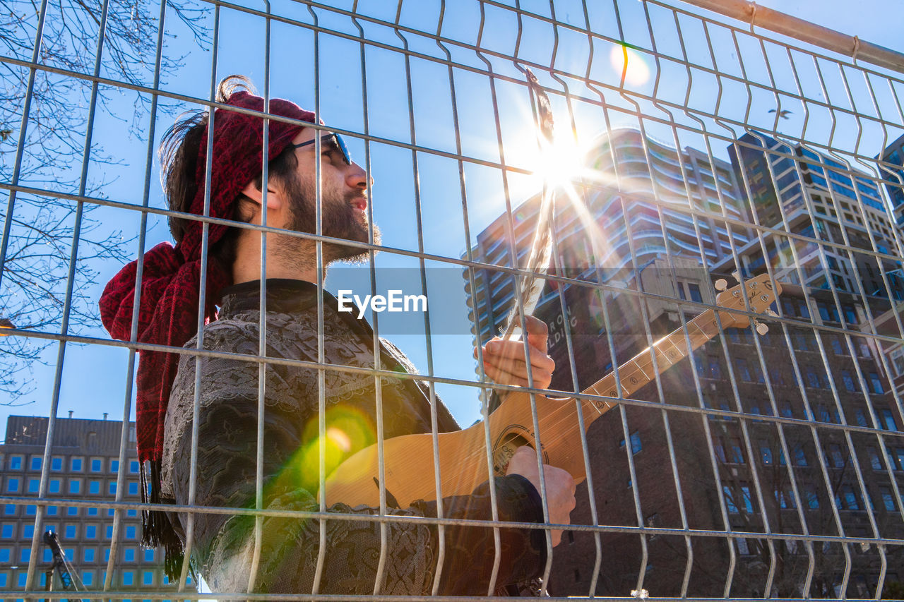 LOW ANGLE VIEW OF MAN AGAINST BRIGHT SKY