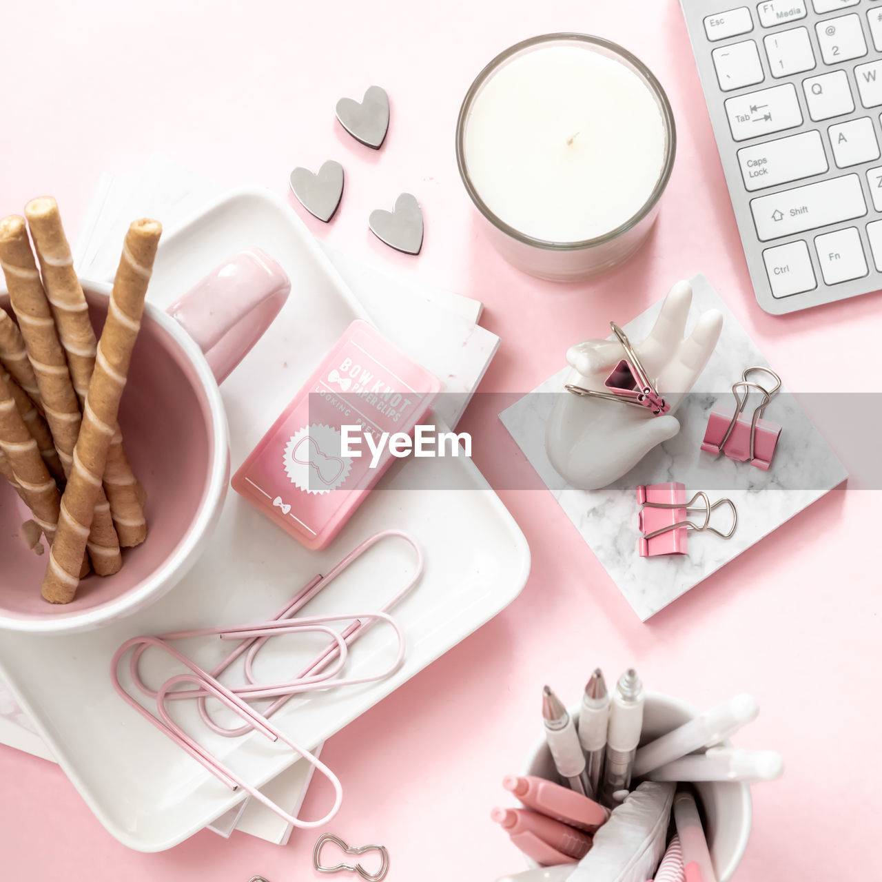 A feminine workspace, keyboard of a computer on a pink background with copy space