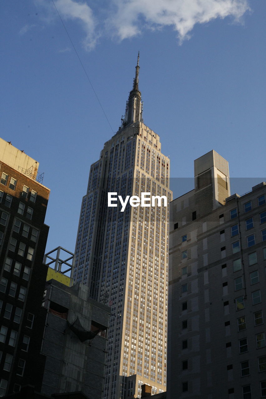 Low angle view of empire state building against sky