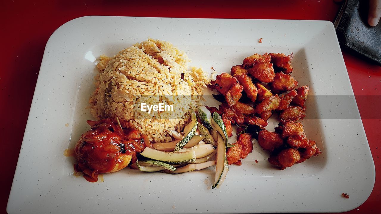 High angle view of meat with rice served on table