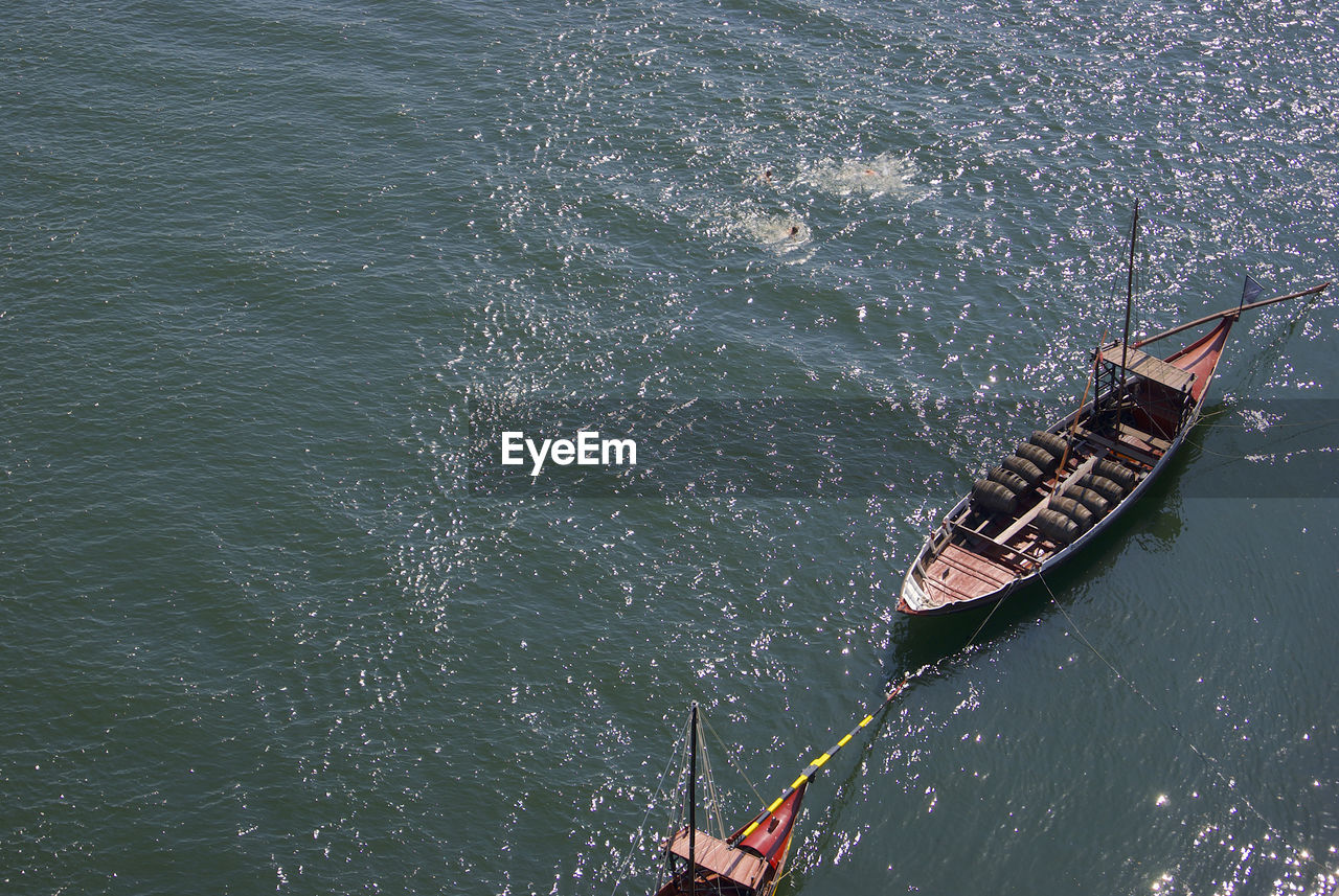 HIGH ANGLE VIEW OF BOAT SAILING IN SEA