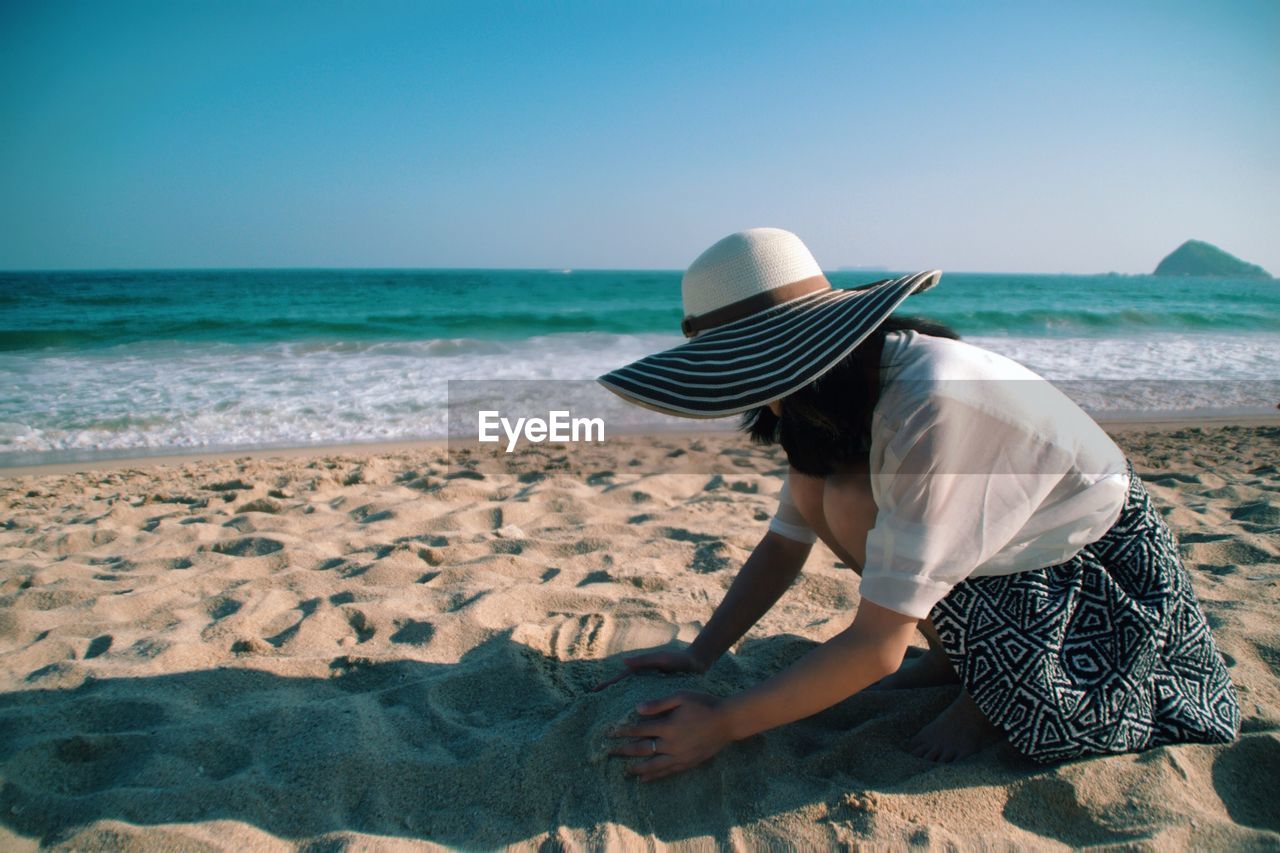 Woman playing on beach against sea