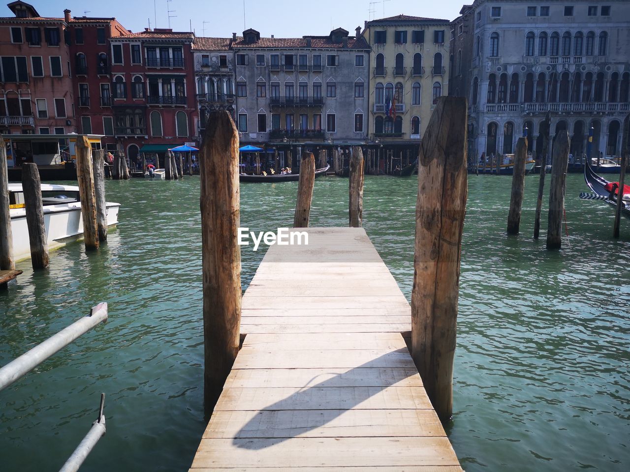 Wooden posts in canal amidst buildings in city