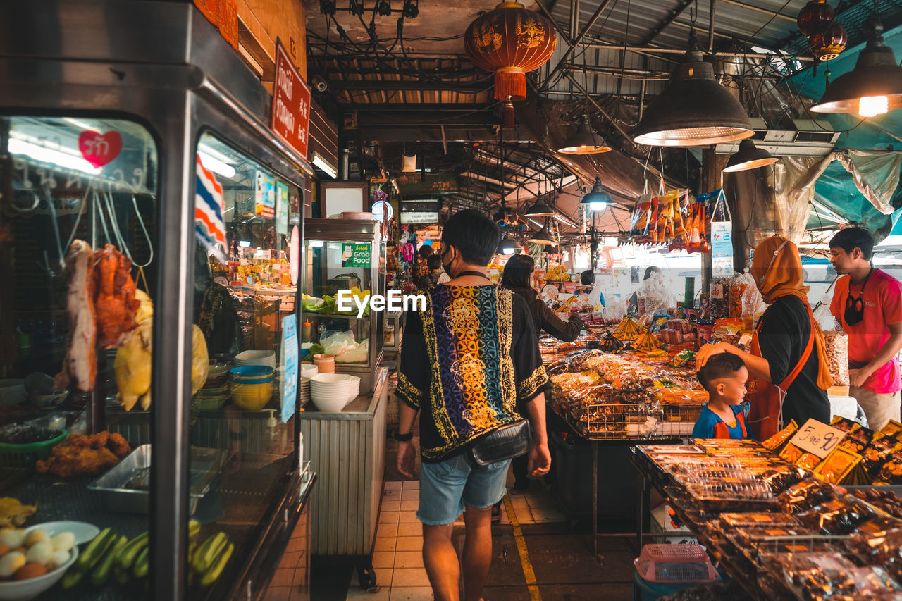 GROUP OF PEOPLE AT MARKET STALL