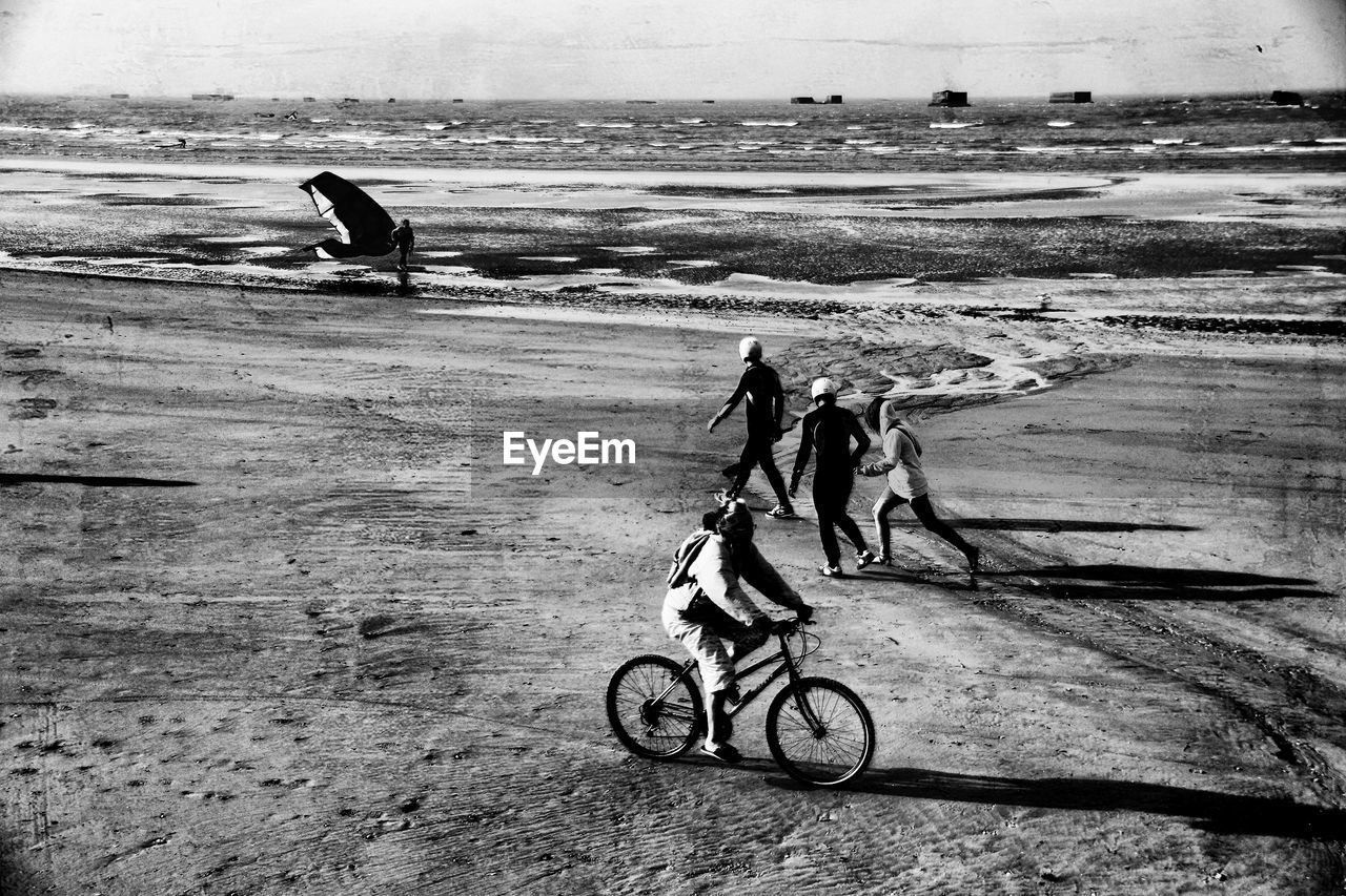 MAN WITH PEOPLE ON BEACH