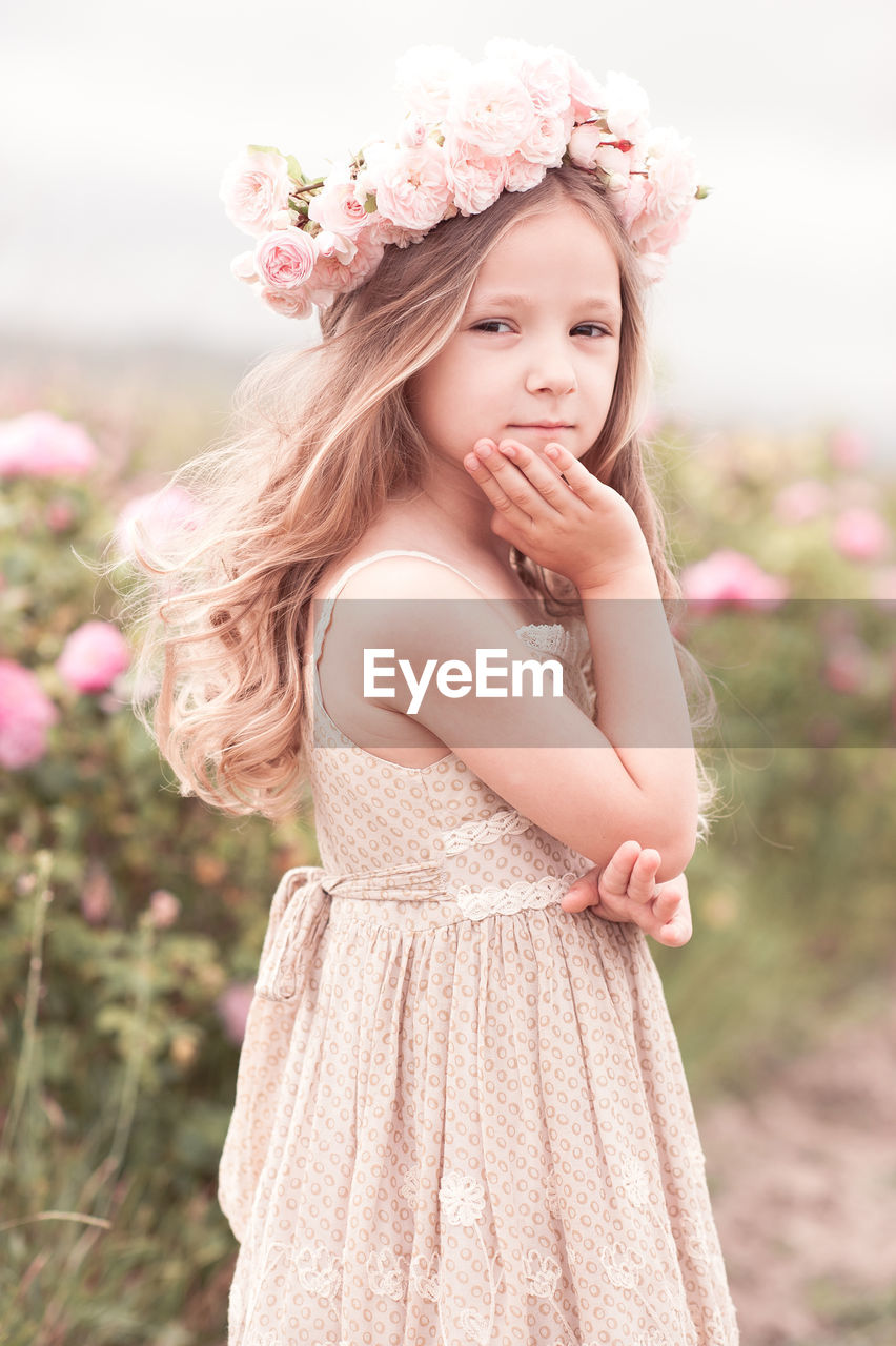 Cute girl wearing wreath standing at farm