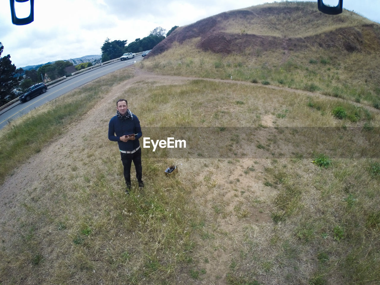 High angle view of man standing on field by hill