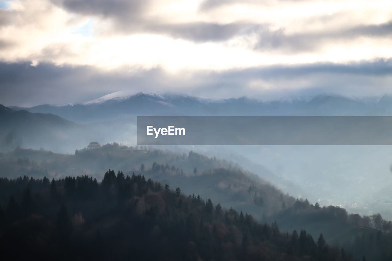 fog, environment, scenics - nature, mountain, tree, sky, cloud, landscape, beauty in nature, forest, mist, morning, dawn, nature, plant, land, tranquility, mountain range, tranquil scene, sunrise, pine tree, no people, coniferous tree, pinaceae, pine woodland, winter, outdoors, wilderness, sun, woodland, cold temperature, mountain peak, idyllic, non-urban scene, twilight, sunbeam, sunlight, travel, travel destinations, cloudscape, ridge, atmospheric mood, valley, silhouette