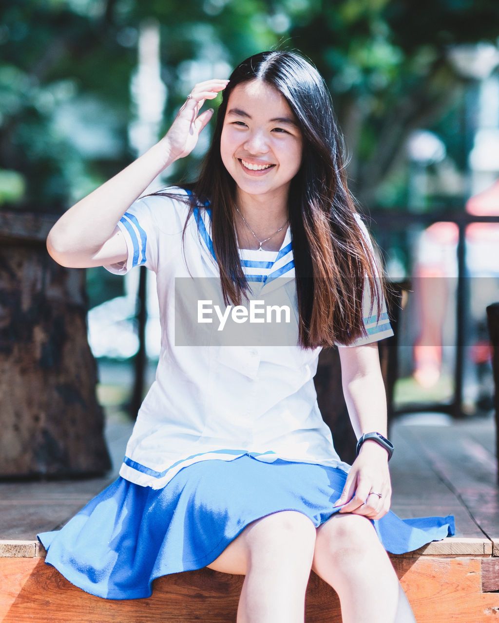 Portrait of smiling young woman sitting outdoors