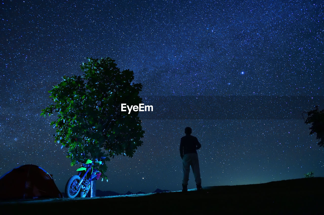 SILHOUETTE MAN STANDING AGAINST SKY AT NIGHT