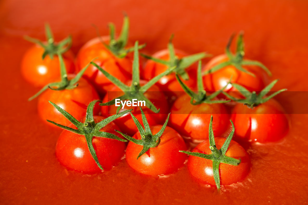 CLOSE-UP OF RED CHILI PEPPERS ON ORANGE TABLE