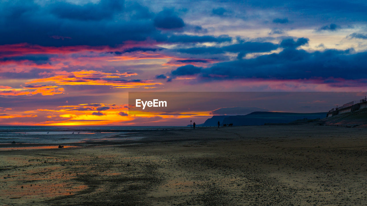 Scenic view of beach against sky during sunset