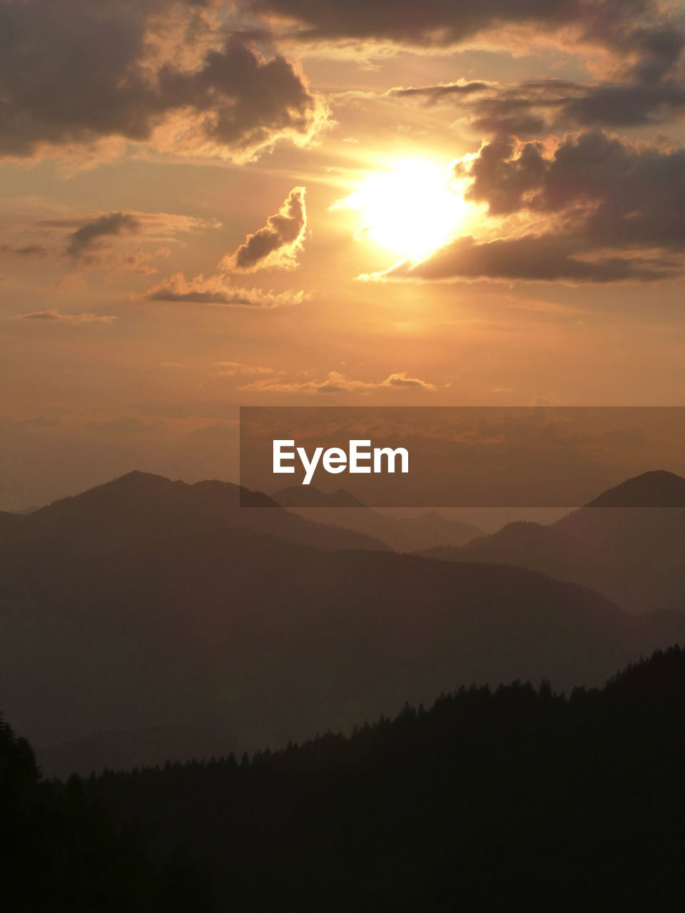 sky, beauty in nature, scenics - nature, sunset, mountain, environment, cloud, sun, tranquility, landscape, nature, tranquil scene, sunlight, silhouette, mountain range, dawn, sunbeam, idyllic, no people, dramatic sky, outdoors, fog, non-urban scene, land, tree, orange color, afterglow, travel, atmospheric mood, travel destinations, back lit, plant, forest, awe, tourism, twilight, remote