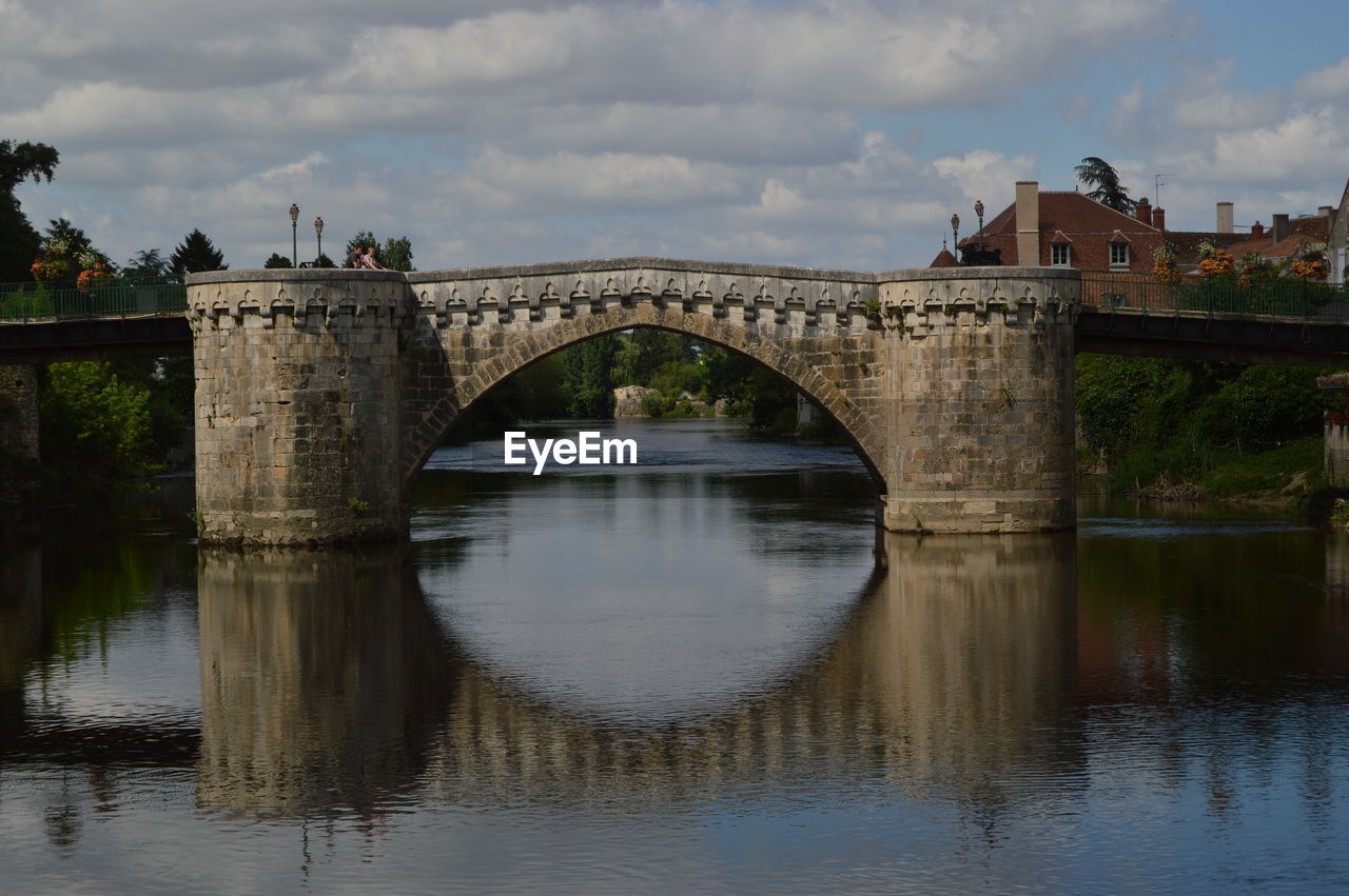 Arch bridge over river against sky