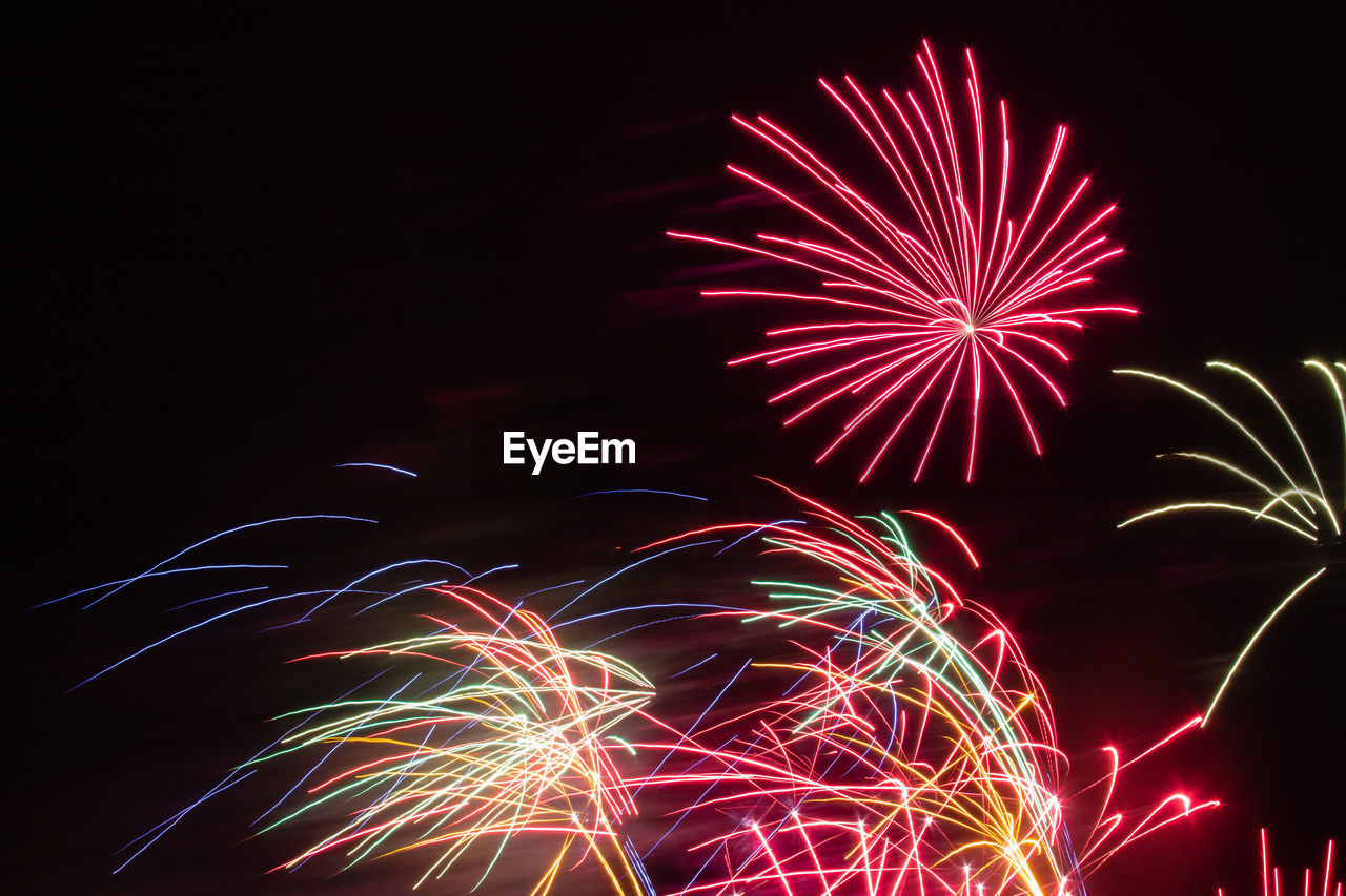 Low angle view of firework display at night