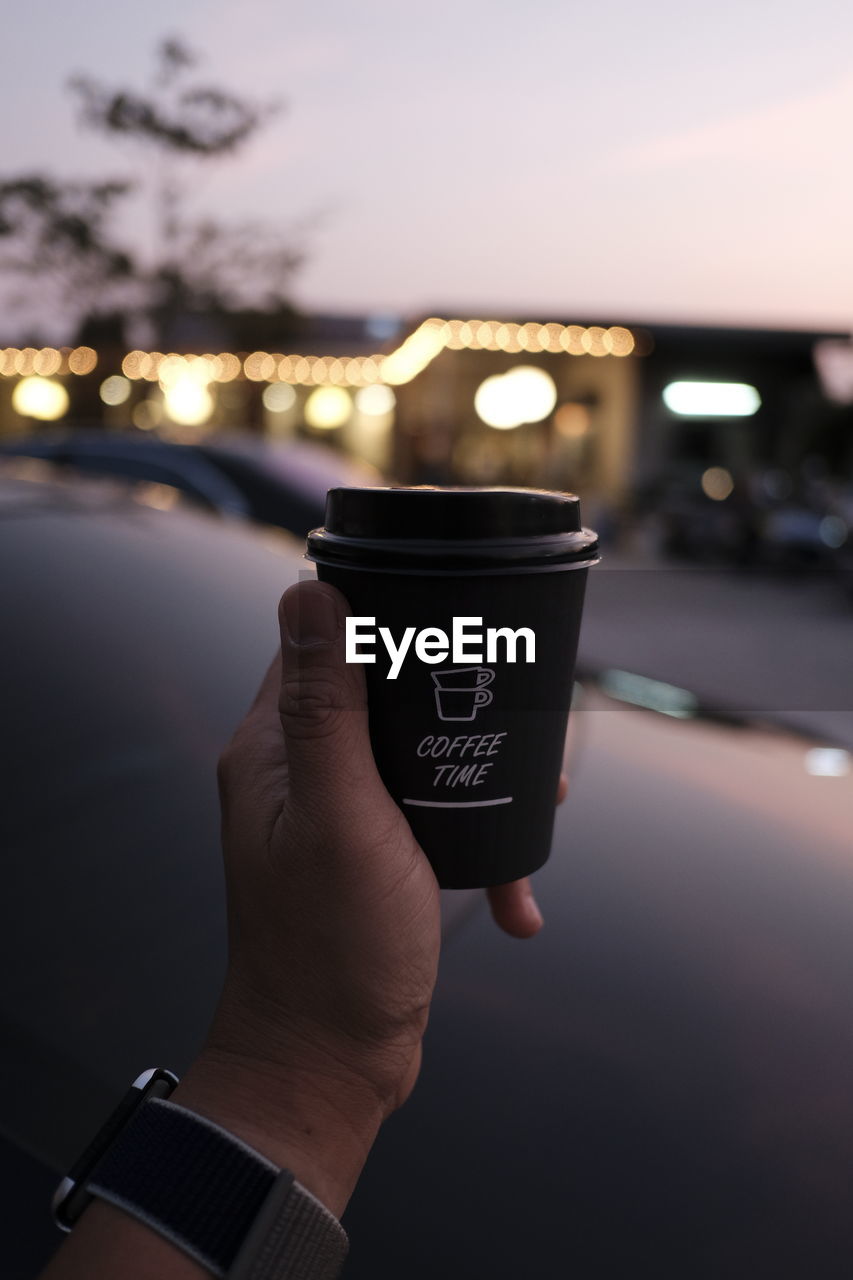 Cropped hand of man holding coffee cup